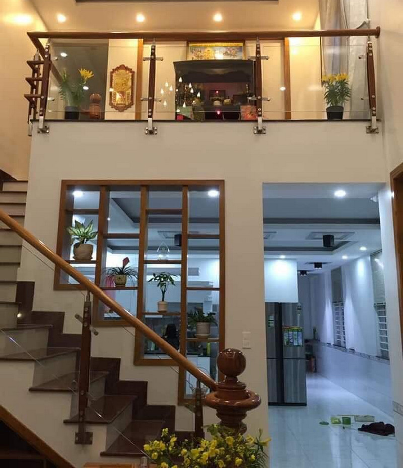 Cầu thang lên tầng gác lửng ngăn cách phòng khách với phòng bếp và phòng ăn